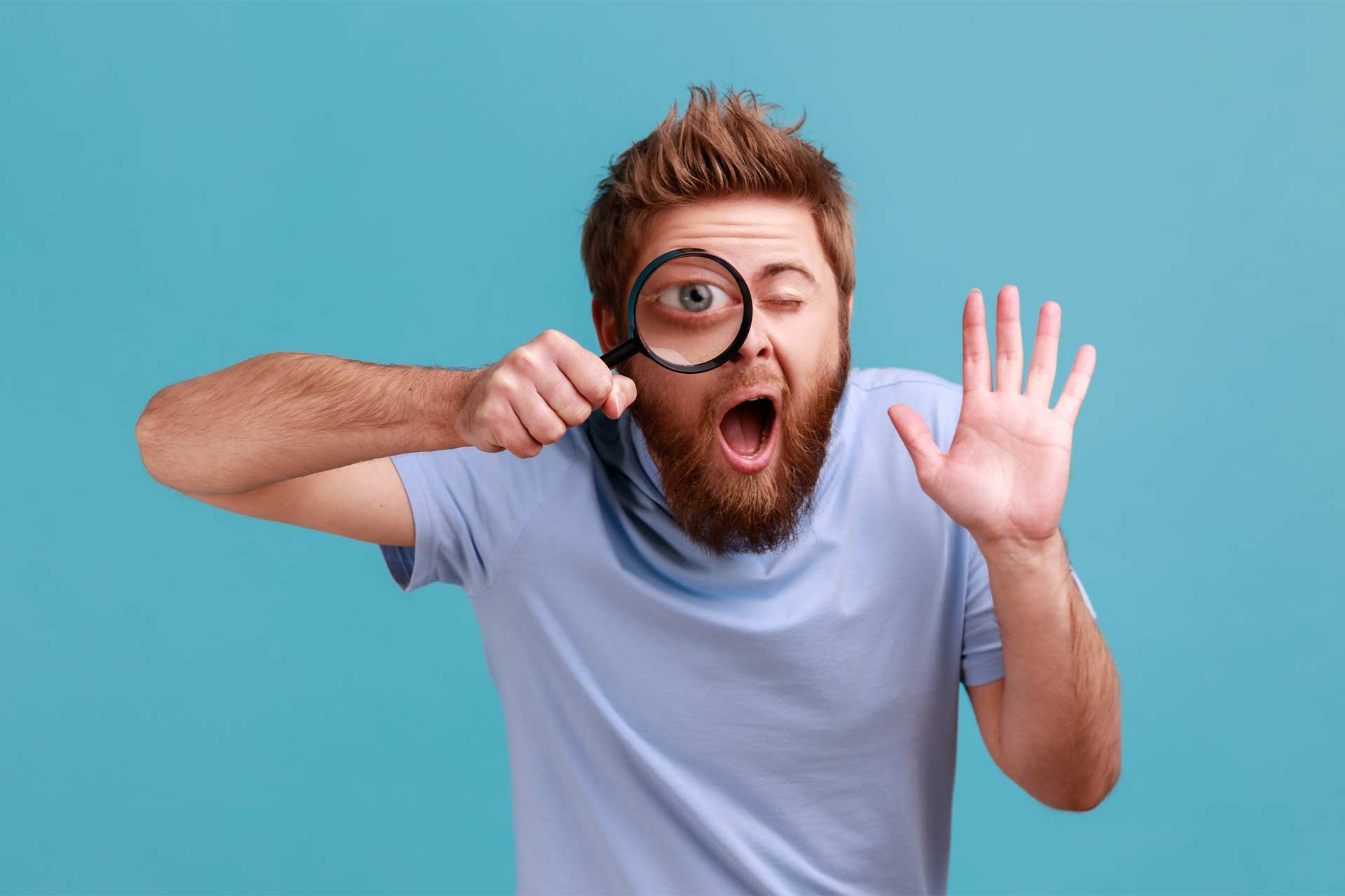 Bearded man with magnifying glass, highlighting brand message, blue background.